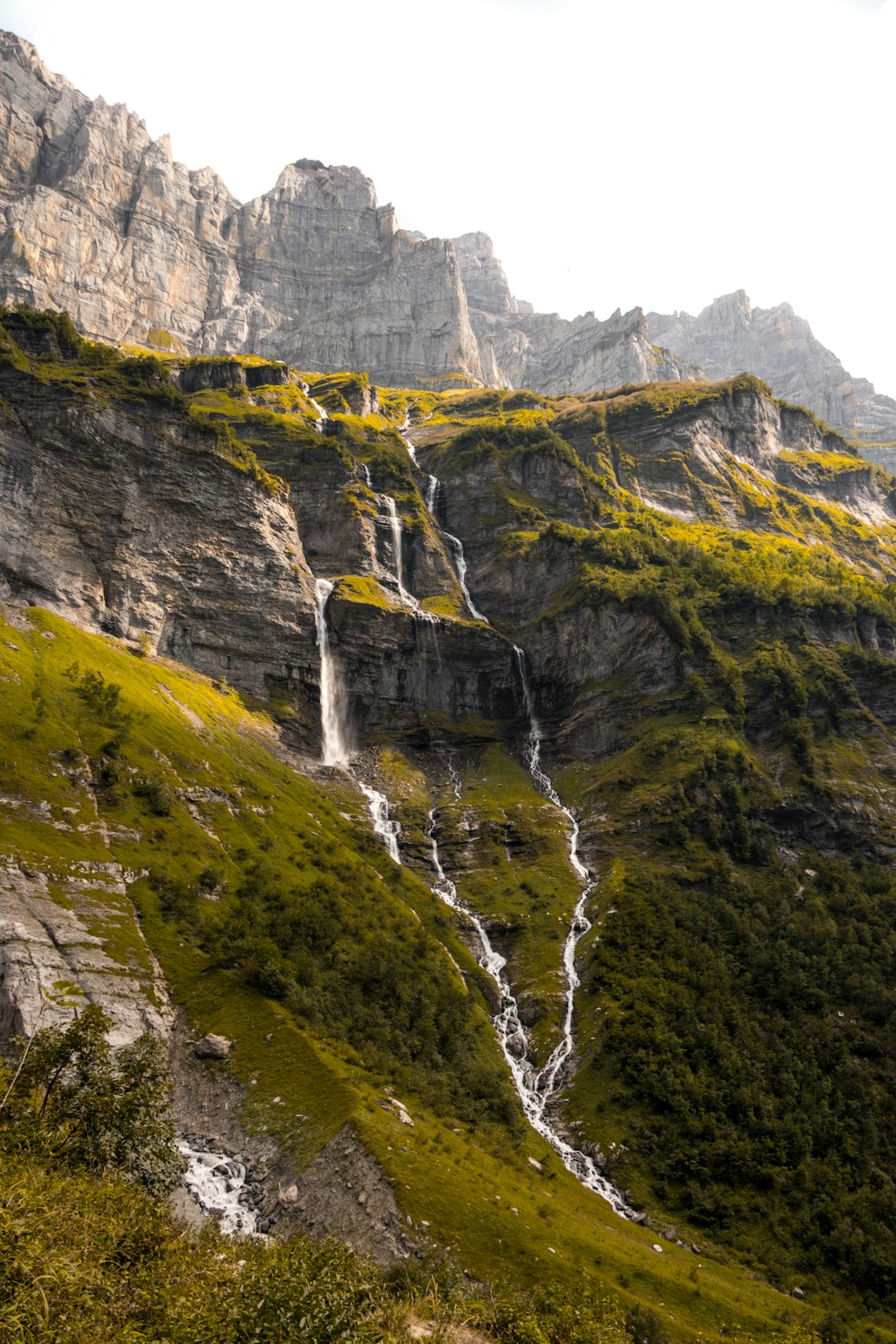 Wasserfälle auf grünem Gras bedeckten Berg während des Tages