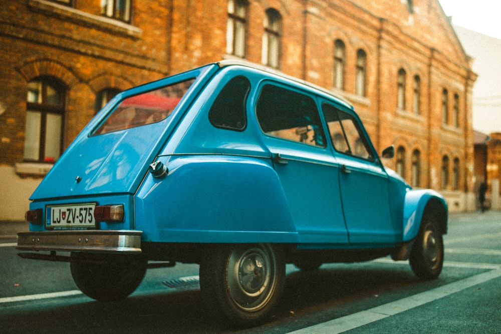 blue car parked on the side of the road during daytime