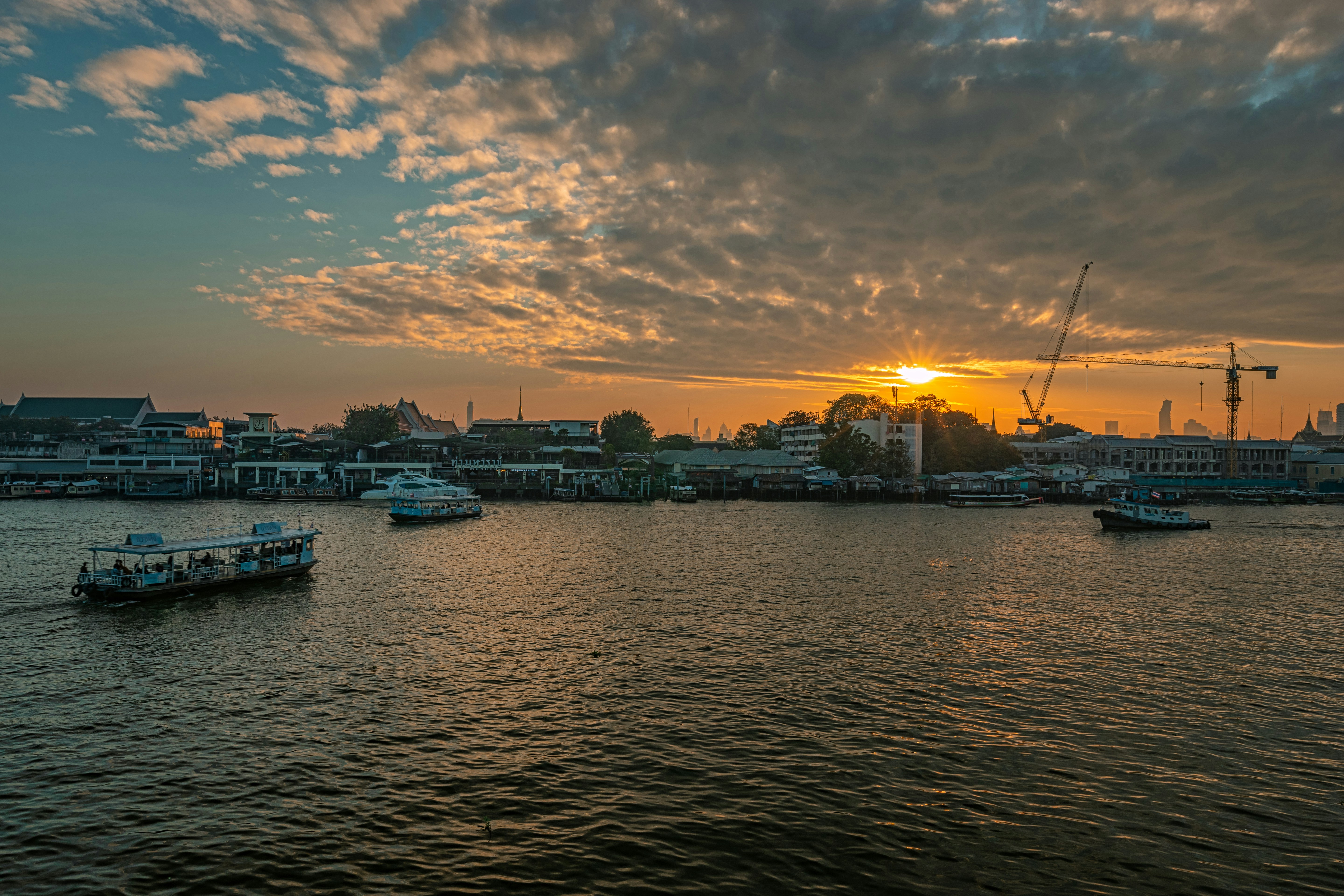 white and blue boat on dock during sunset
