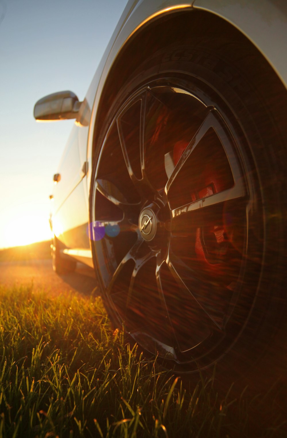 black and red car wheel on green grass during sunset