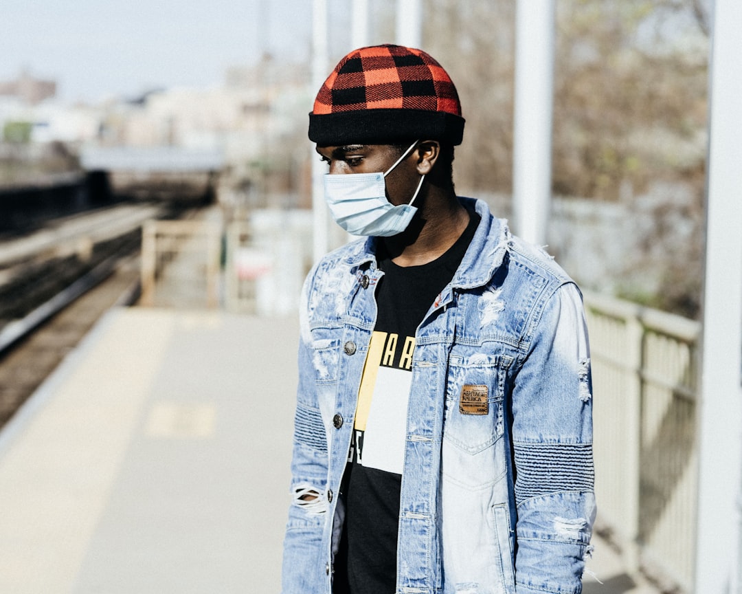 man in blue denim jacket wearing red and black helmet