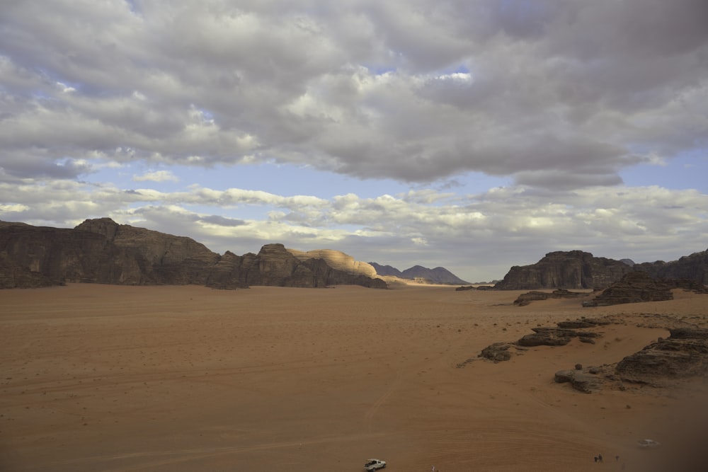 brown sand under white clouds during daytime