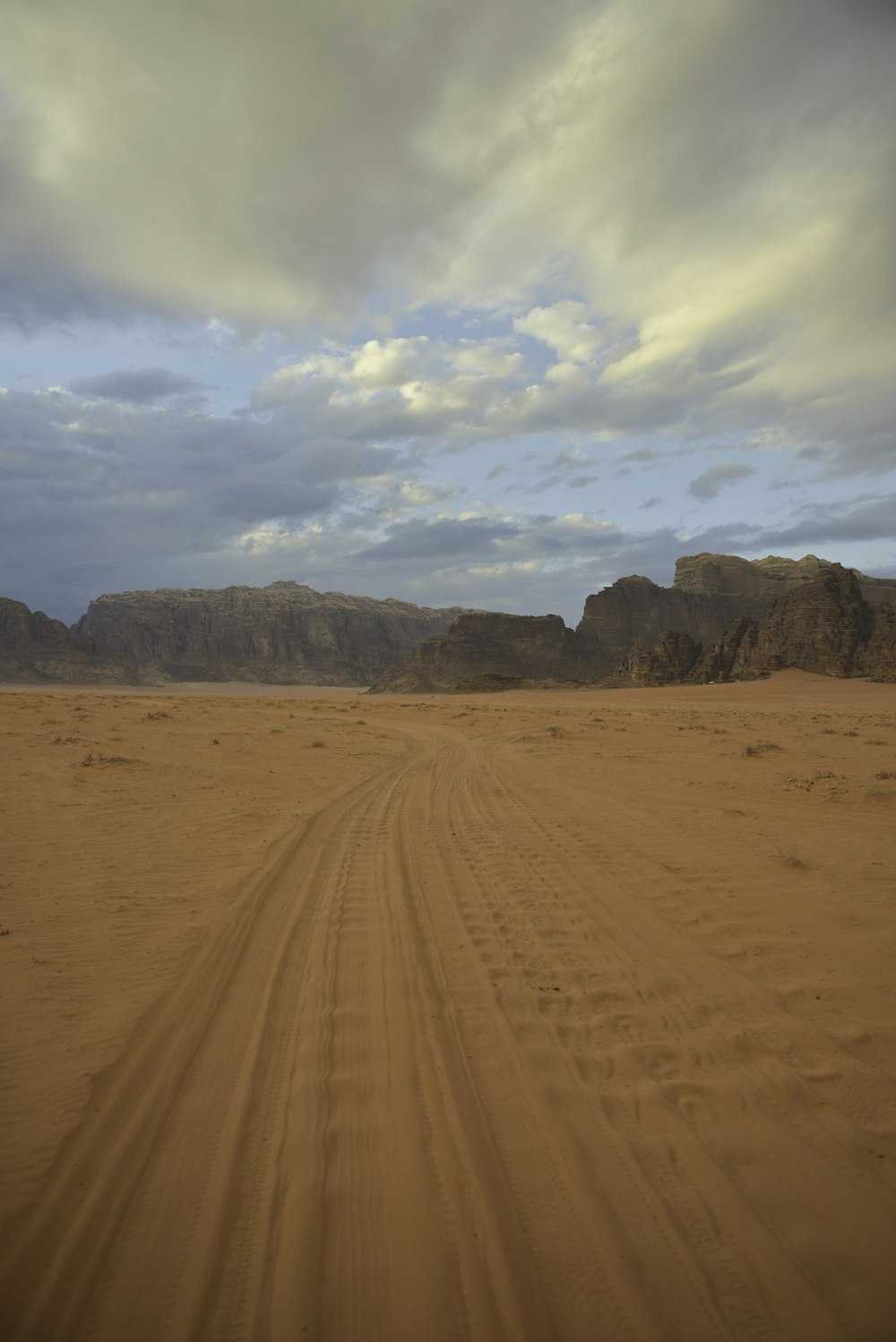 brown sand under white clouds during daytime