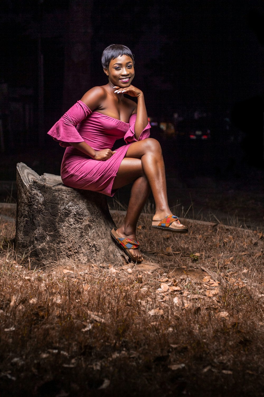 woman in purple dress sitting on brown rock