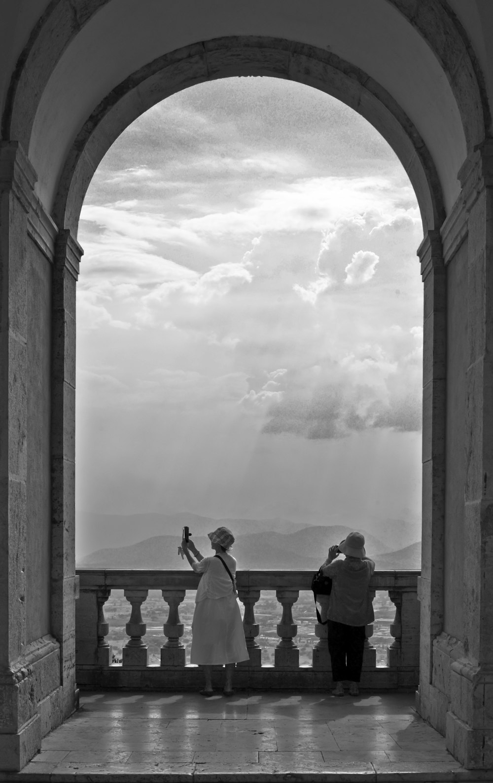 grayscale photo of couple standing on balcony