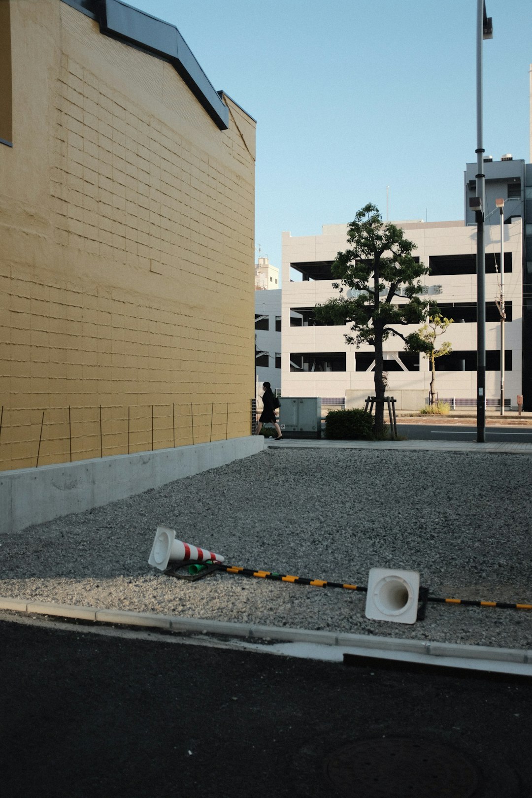 white and yellow traffic cone near brown concrete building during daytime