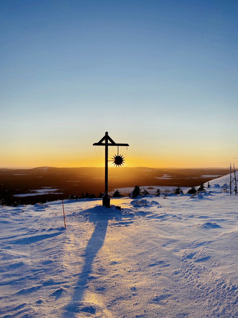 black street light on snow covered ground during sunset