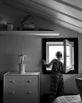 woman in black and white floral dress standing in front of mirror