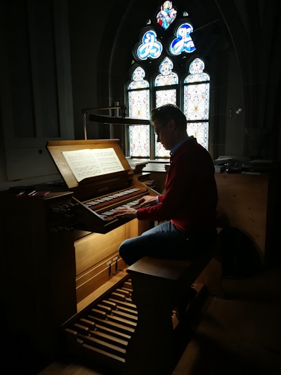 A peaceful musician playing guitar in a sunlit church, surrounded by stained glass windows.