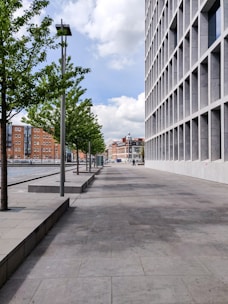 gray concrete road between white concrete buildings during daytime