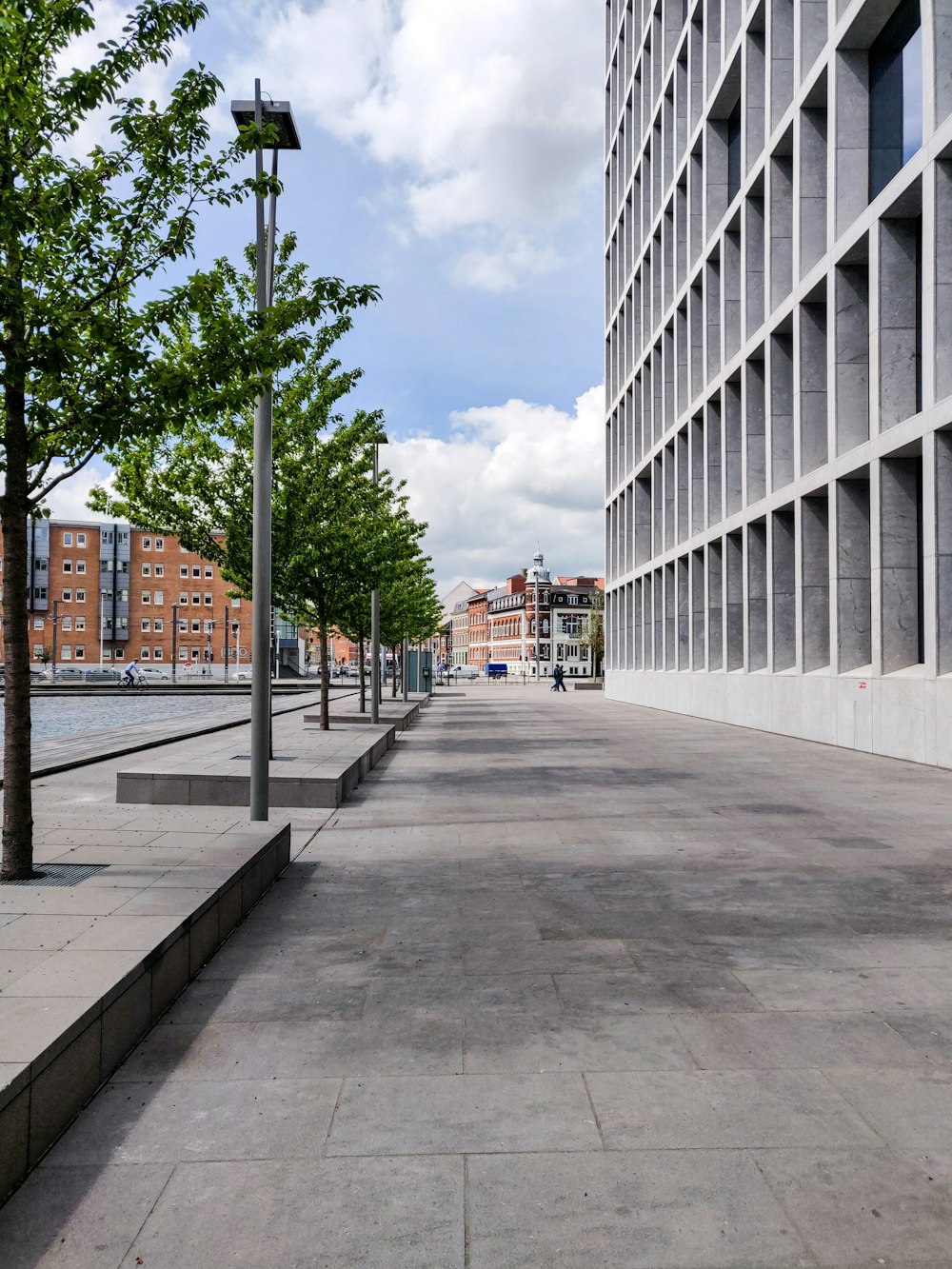 gray concrete road between white concrete buildings during daytime