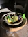 A rustic wooden table set with colorful stoneware plates and bowls, sunlight streaming in.