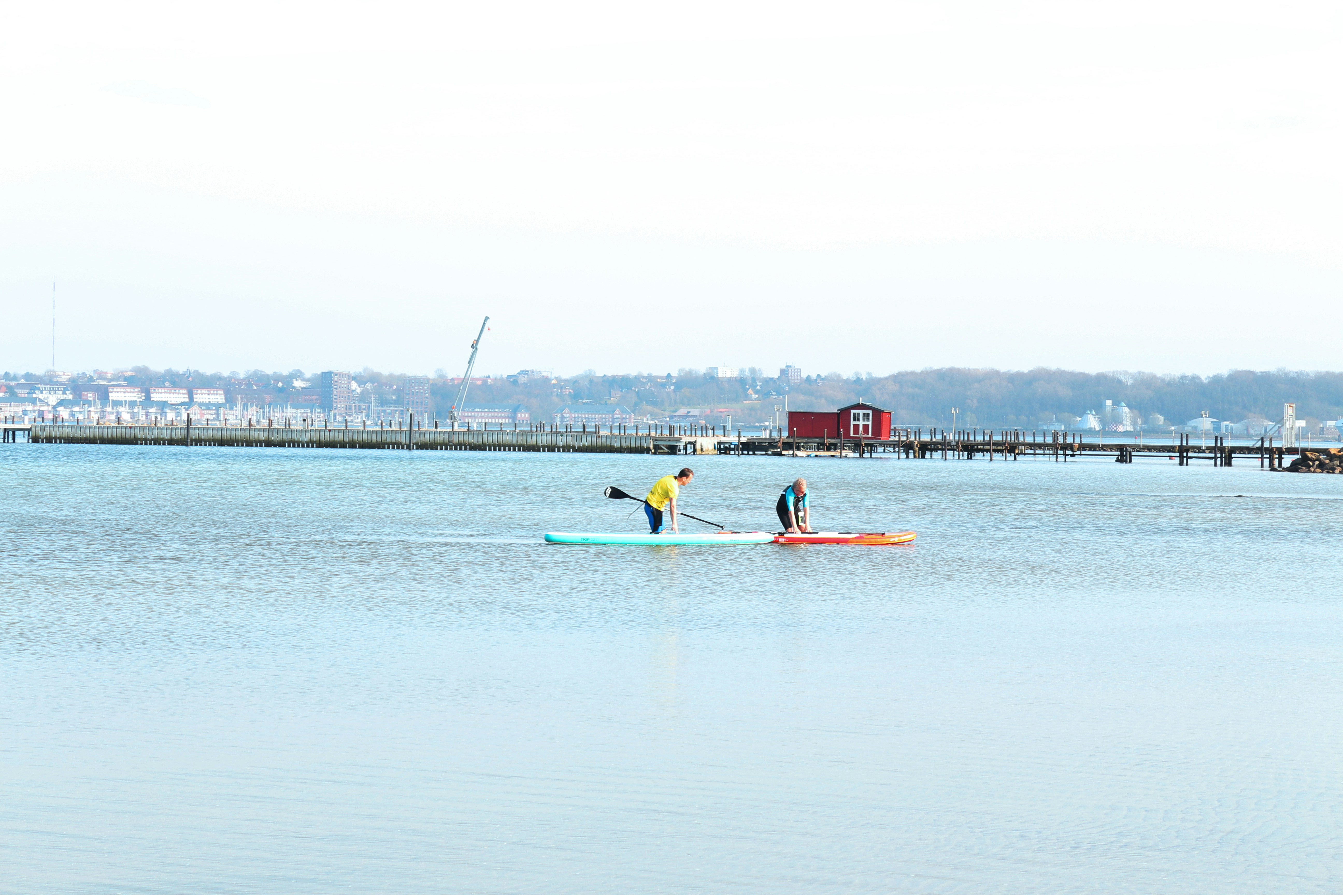 2 people riding on yellow kayak on sea during daytime