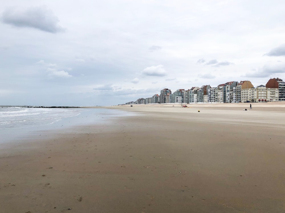 white sand beach near city buildings during daytime