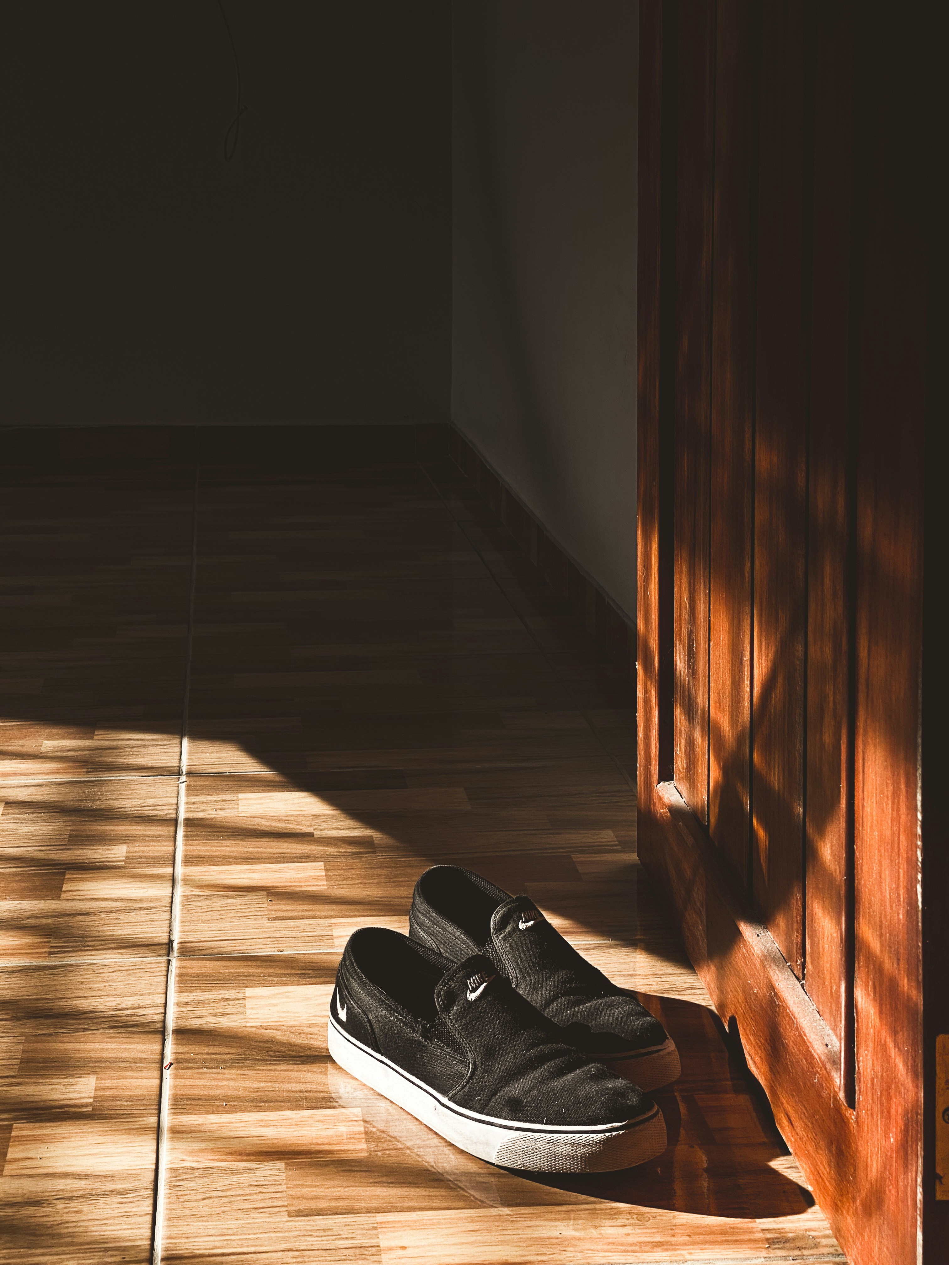black and white nike sneakers on brown floor tiles
