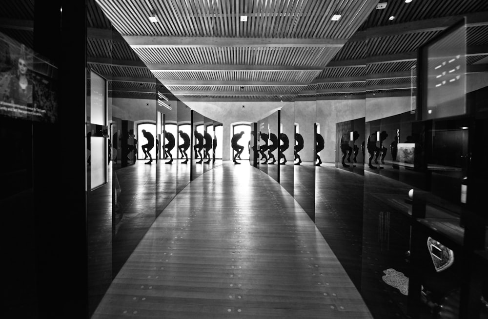 grayscale photo of people walking on hallway