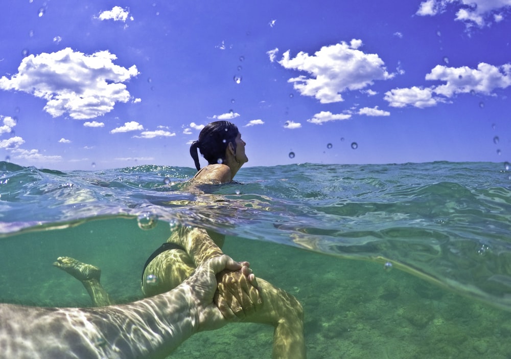woman in green bikini swimming on water