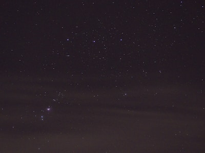 A glowing purple star shining over a night sky filled with constellations.