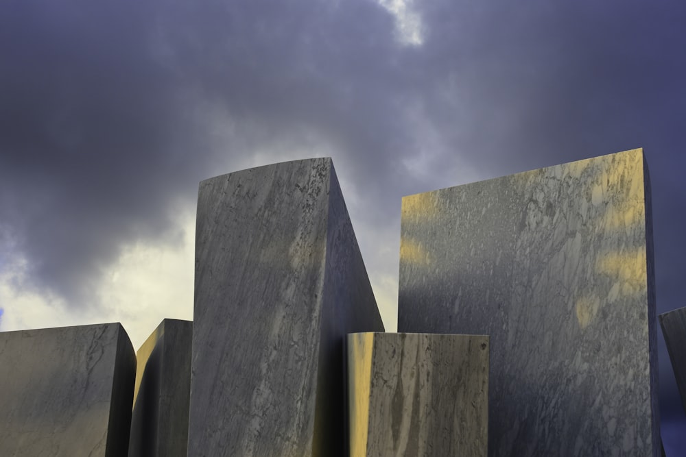 gray concrete wall under white clouds during daytime