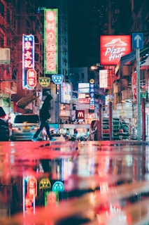 man in black jacket and black pants walking on street during night time