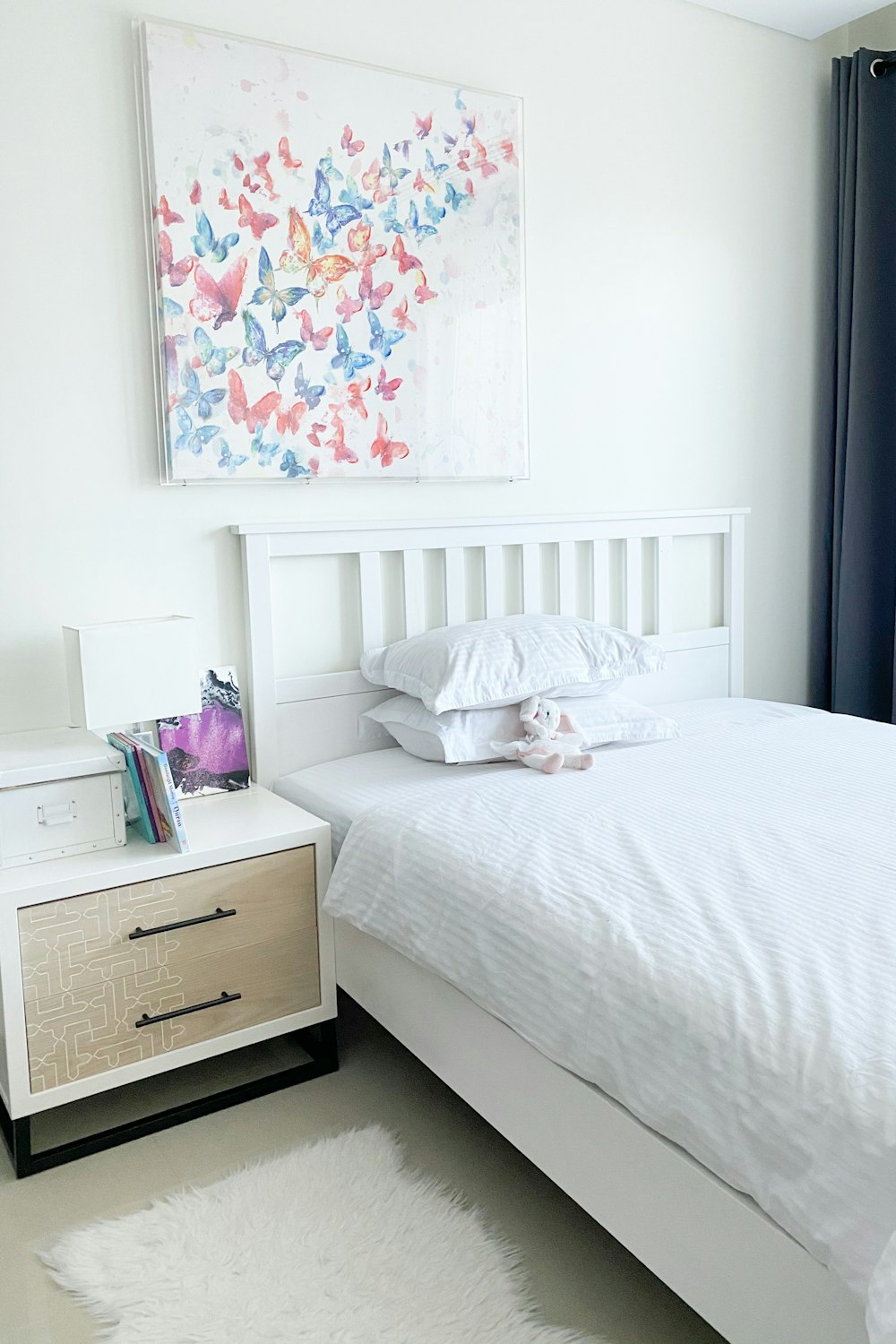 white bed linen near brown wooden drawer