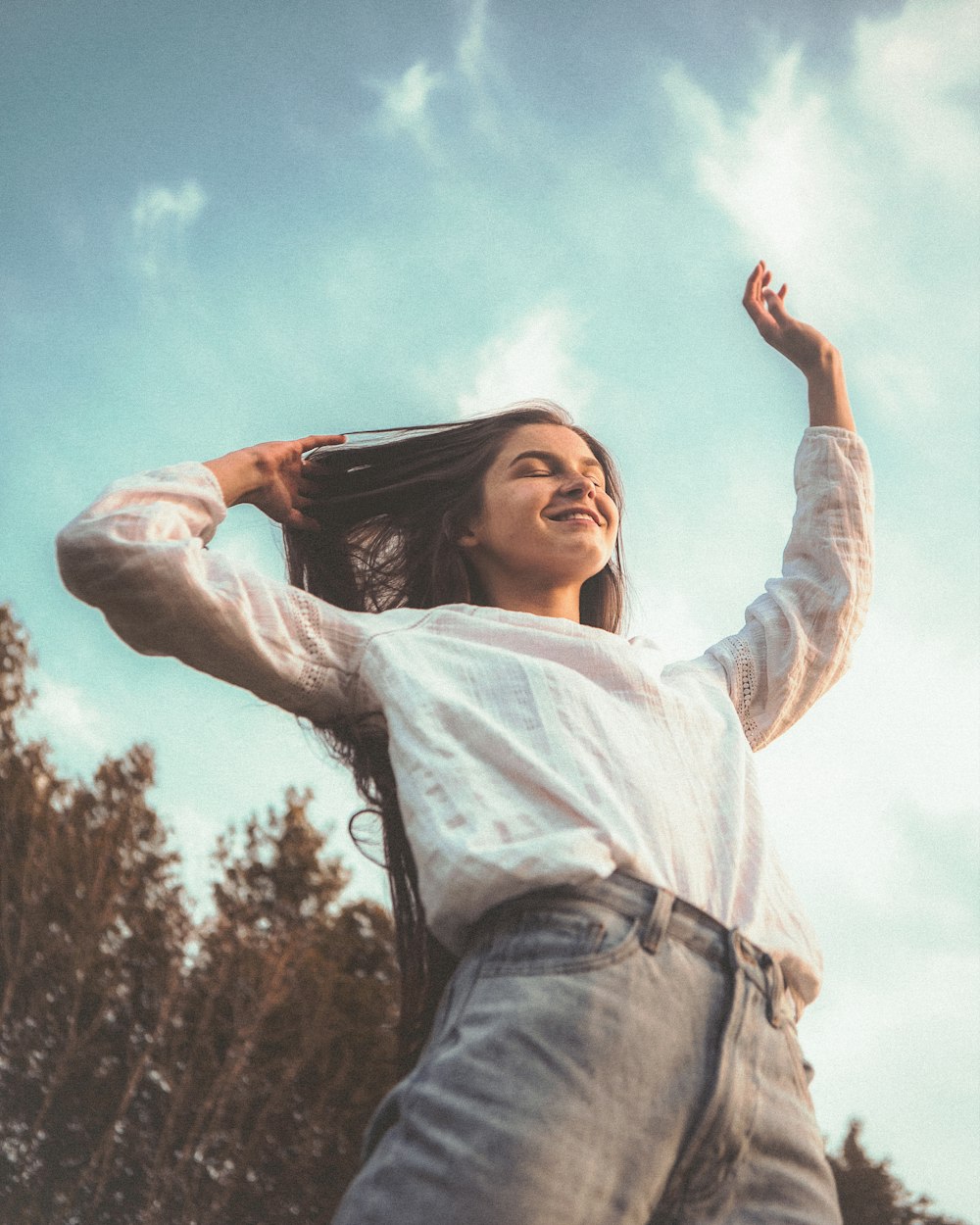 woman in white long sleeve shirt and blue denim jeans