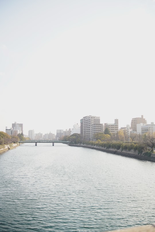 body of water near city buildings during daytime in Hiroshima Japan