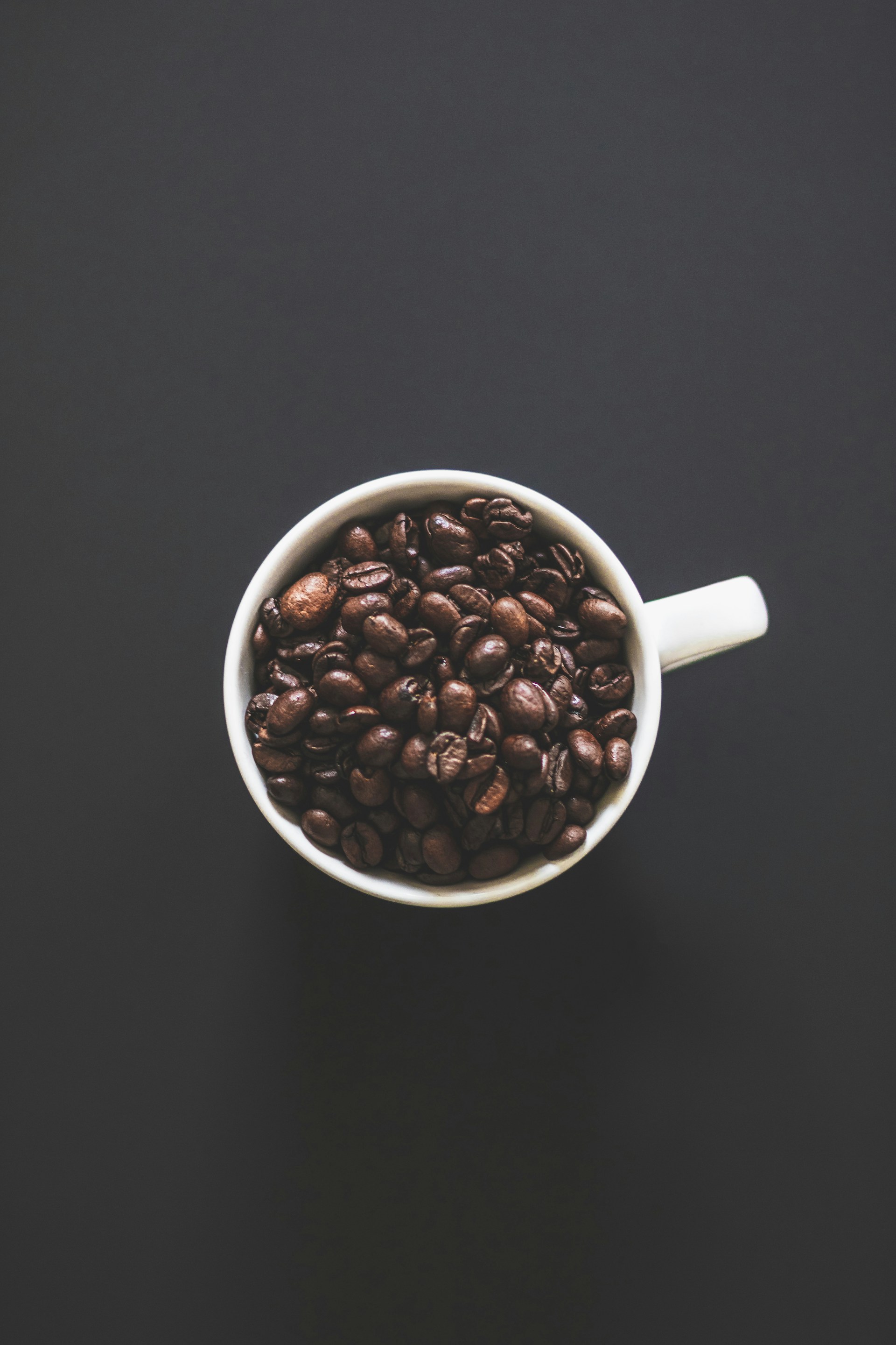 white ceramic mug with coffee beans