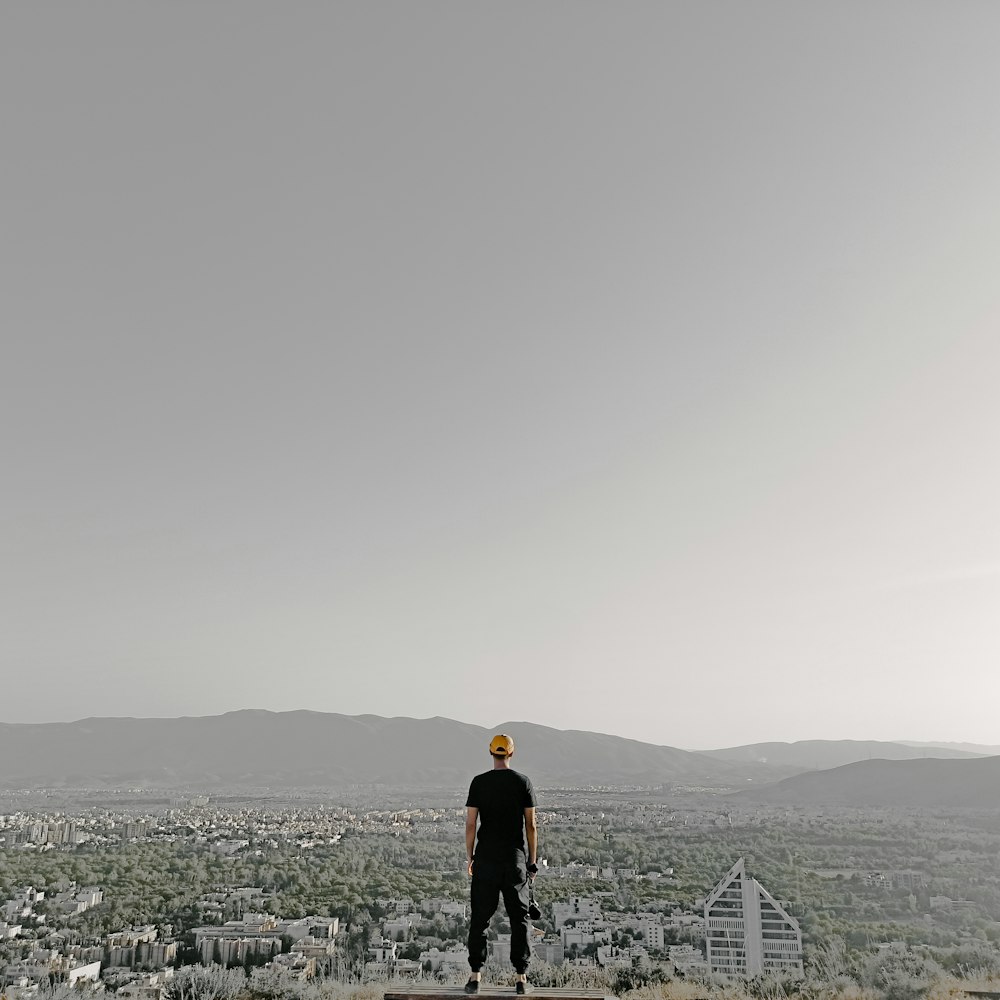 man in black jacket standing on top of mountain during daytime