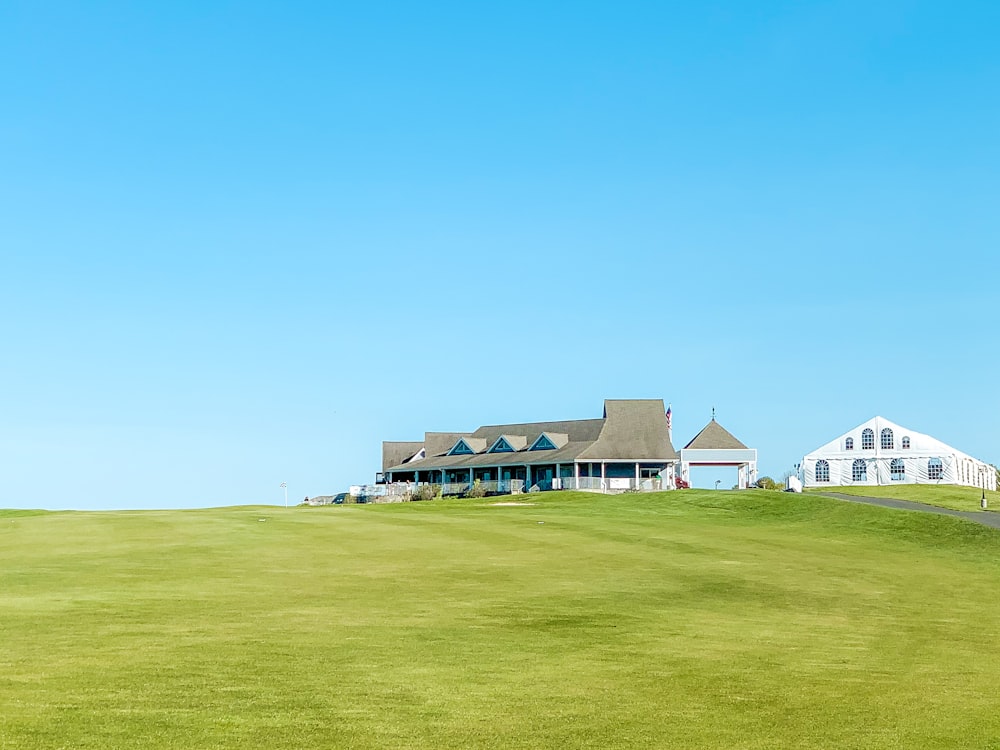 white and black house on green grass field under blue sky during daytime