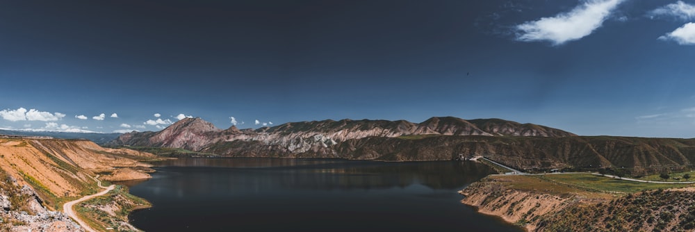 brown and white mountain beside body of water during night time