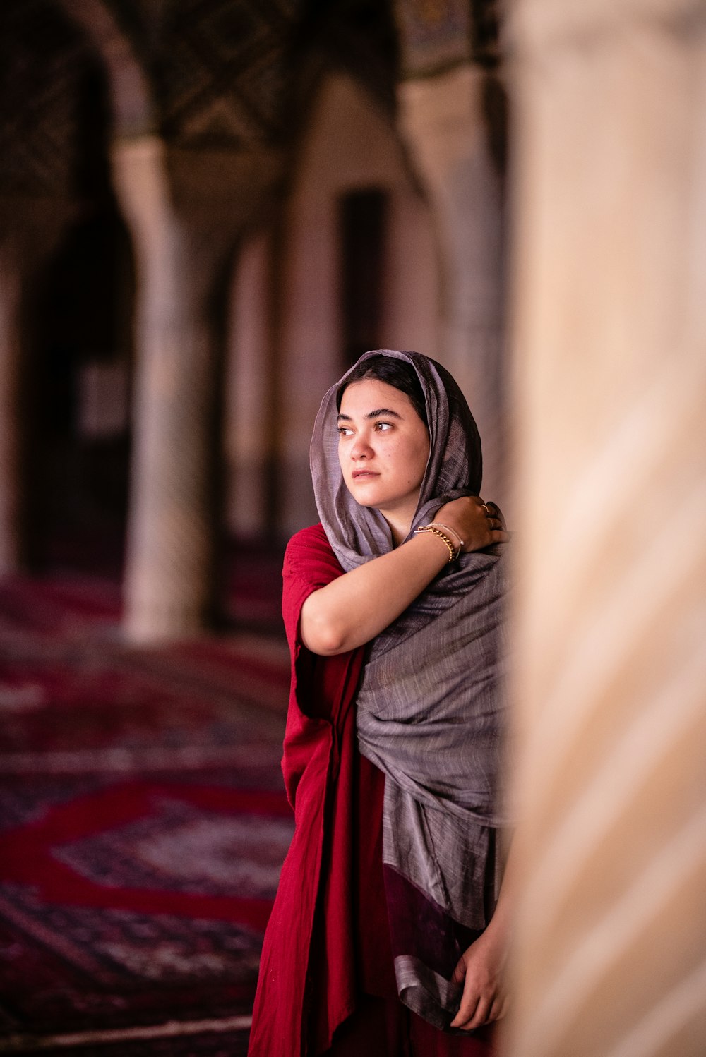 woman in red hijab standing in the middle of the hallway