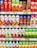 A supermarket shelf displaying a variety of juice cartons. The top row features red and green cartons with tomato and mixed fruit juices. Below are rows of multicolored cartons with flavors including watermelon, vegetable, and pomegranate. Each row is labeled with prices in yellow and white tags.