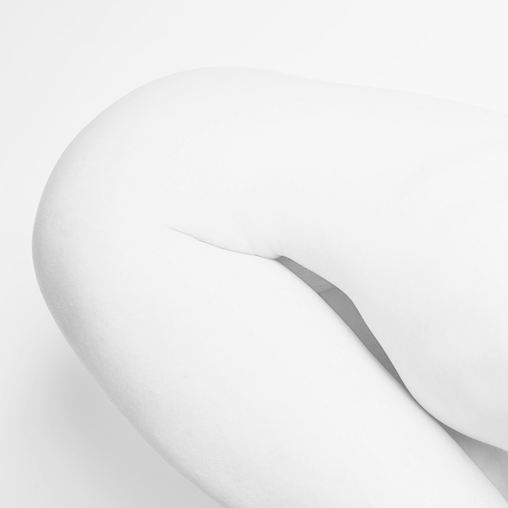 woman in white stockings lying on white surface