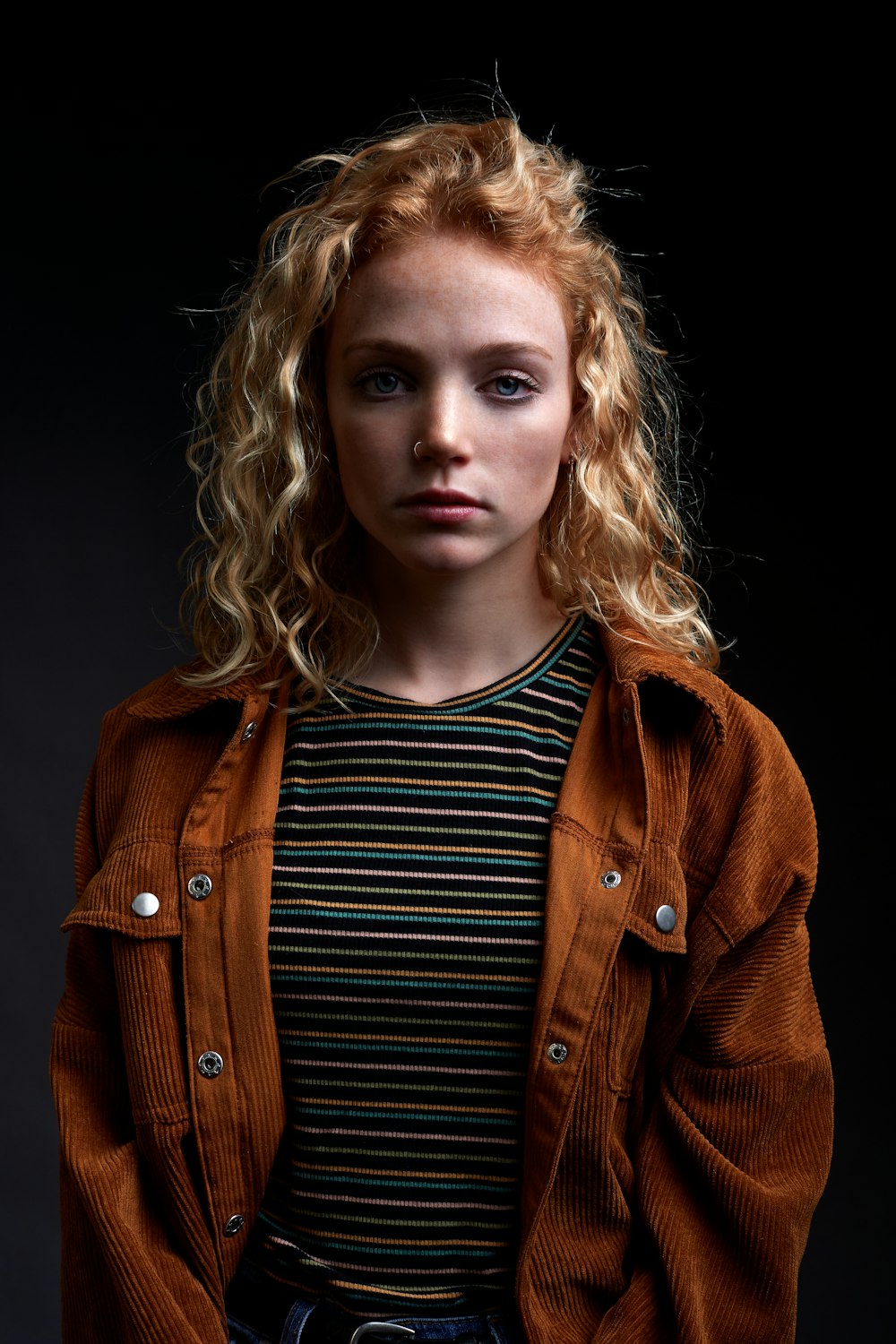 woman in brown coat and black and white striped shirt