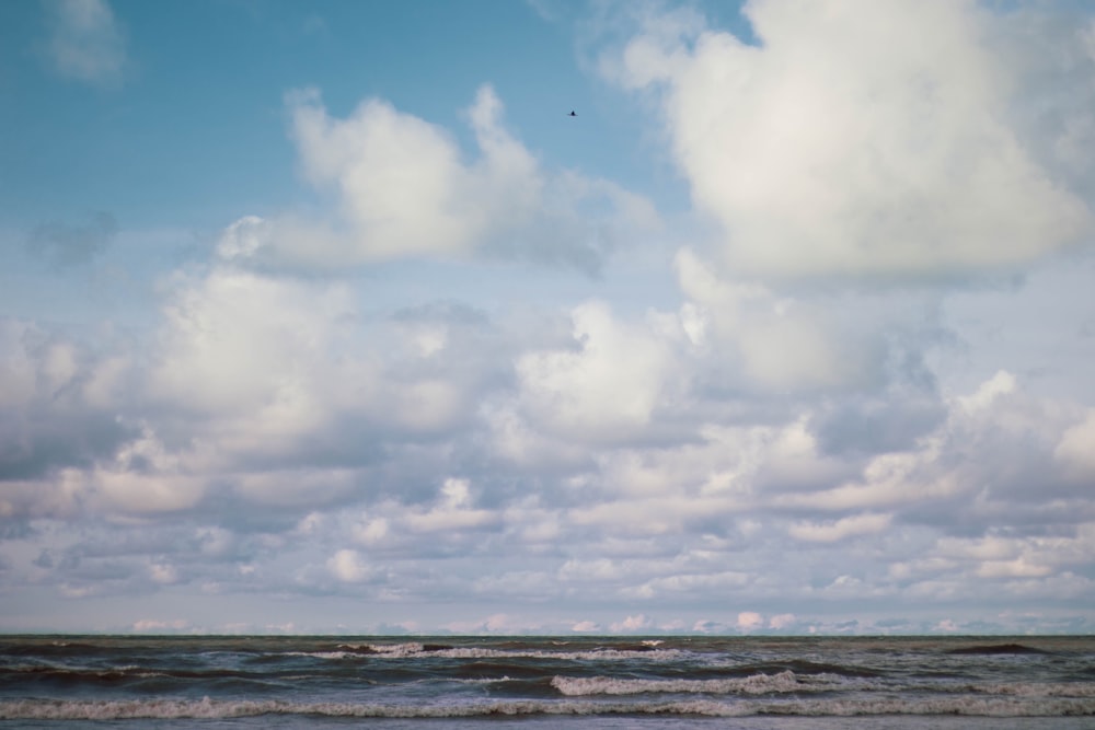 sea under blue sky and white clouds during daytime