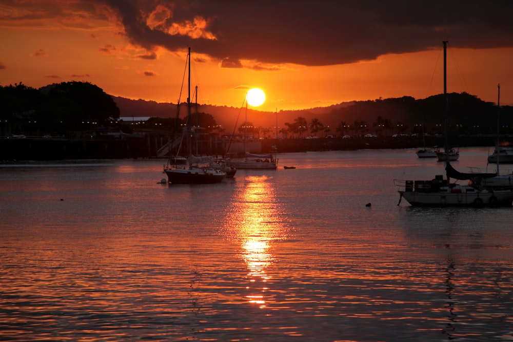 silhouette of boat on sea during sunset