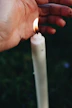 white candle in persons hand