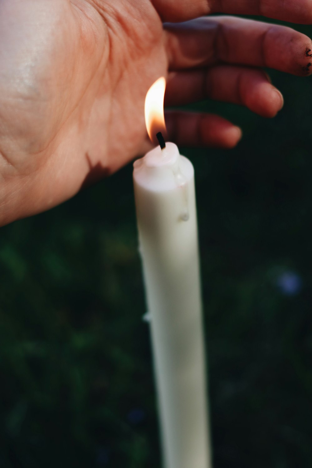 white candle in persons hand