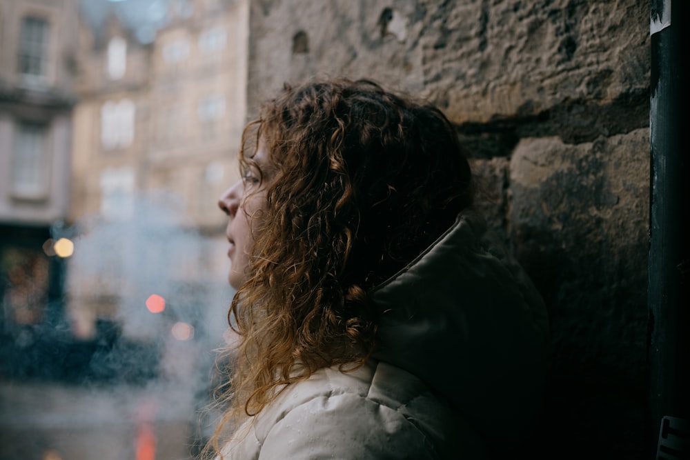 woman in white shirt leaning on wall