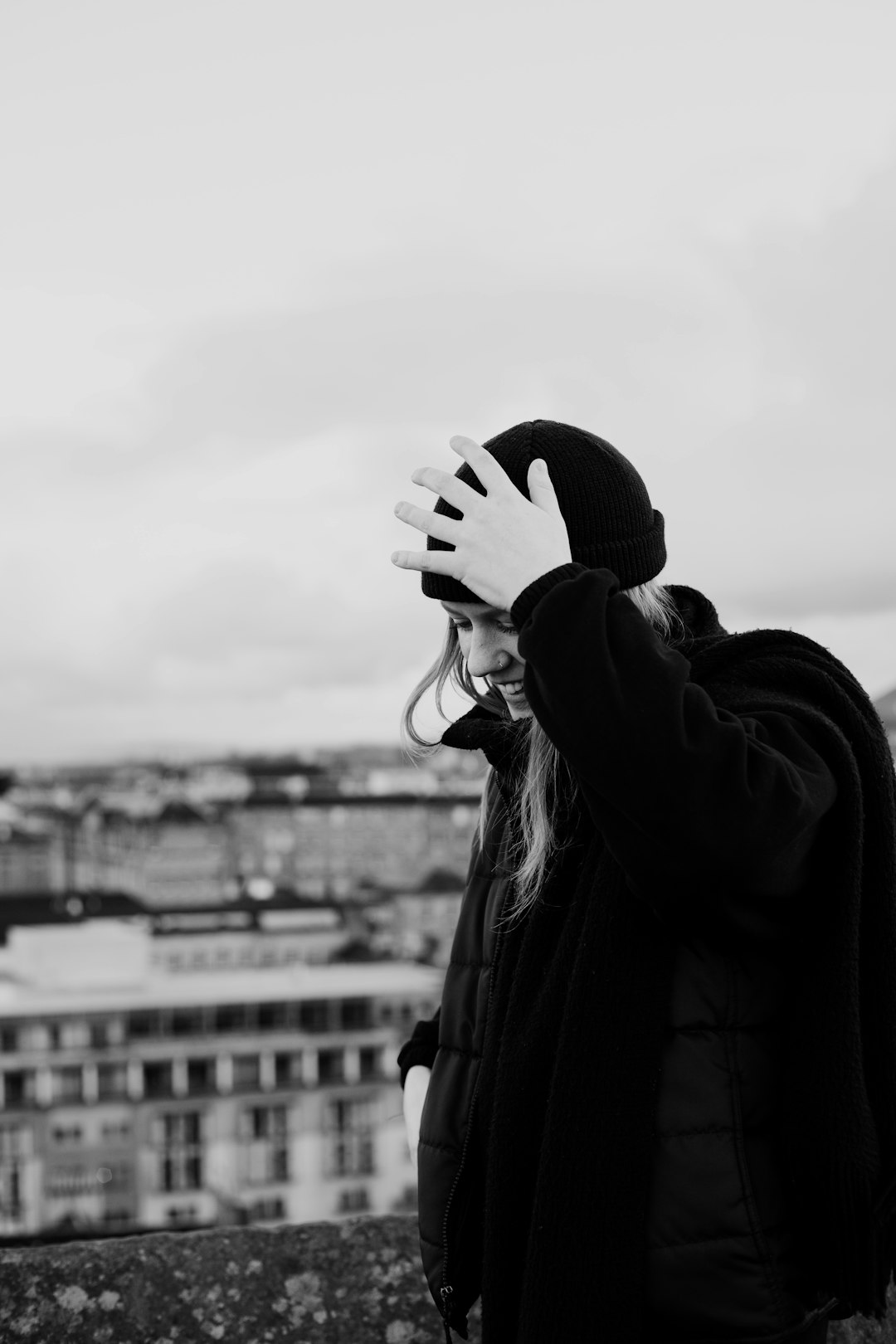 grayscale photo of woman covering face with her hand
