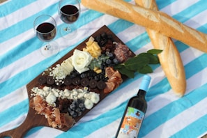 A beautifully arranged portable gourmet cheese and charcuterie board on a rustic linen cloth outdoors