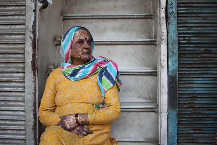 An elderly Indian man sitting outdoors