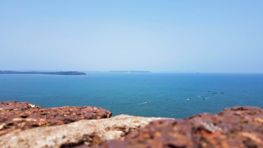 brown rock formation near body of water during daytime