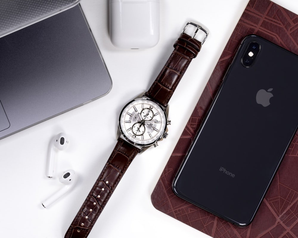 silver round analog watch with brown leather strap