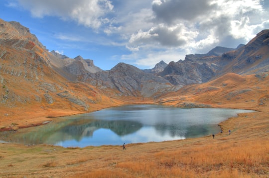 brown mountains near lake under blue sky during daytime in Ubaye France