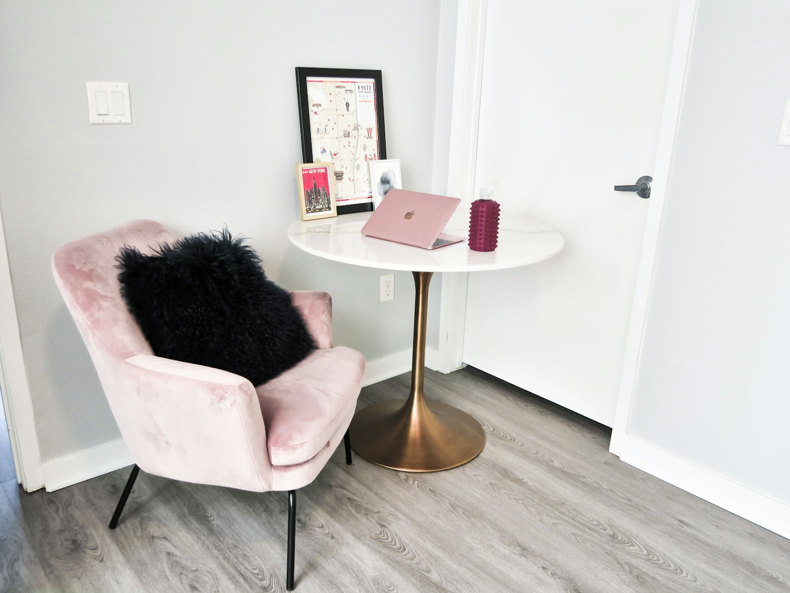pink velvet chair gold round table and laptop workspace for single woman apartment