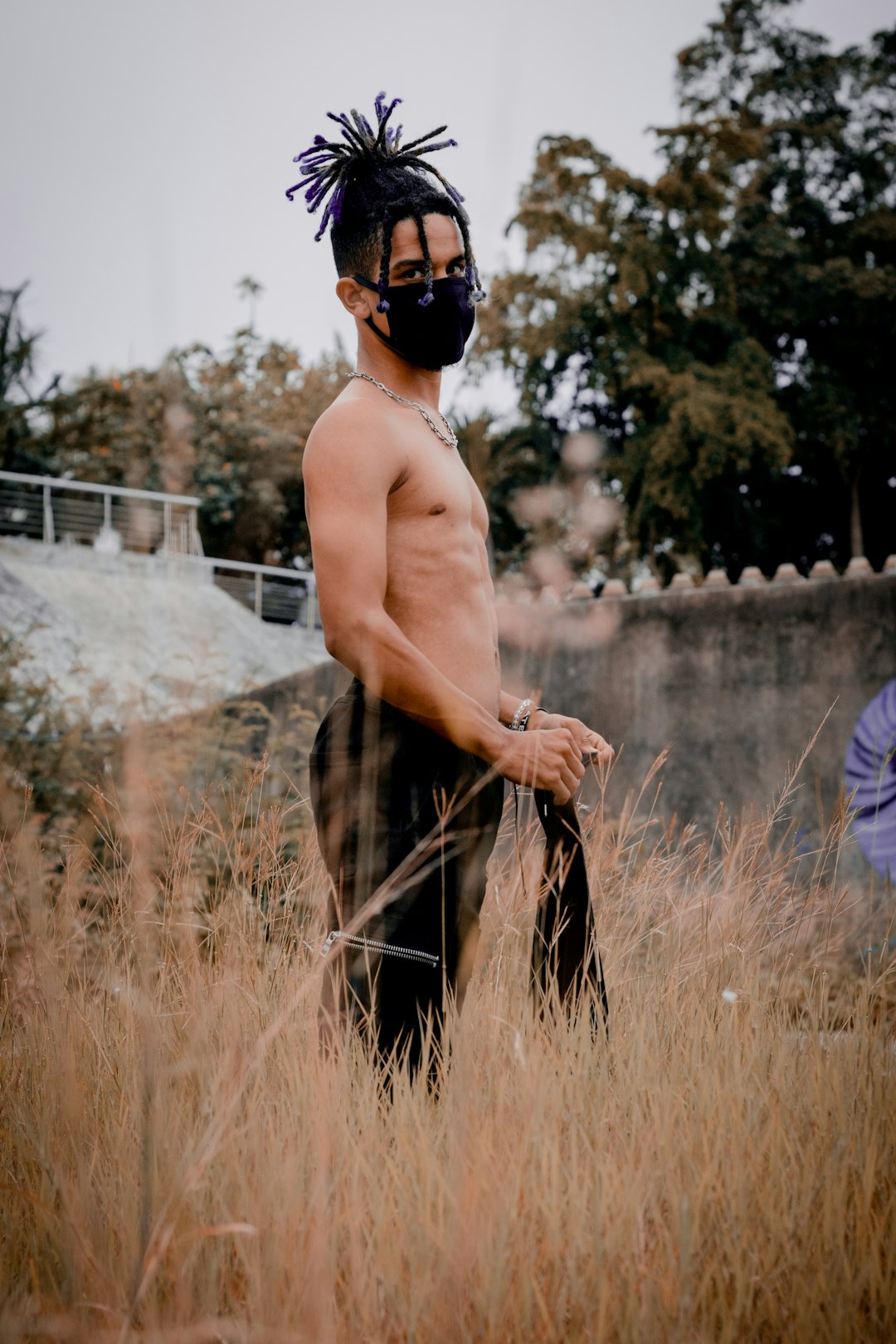 man in black and brown jacket wearing black helmet standing on brown grass field during daytime