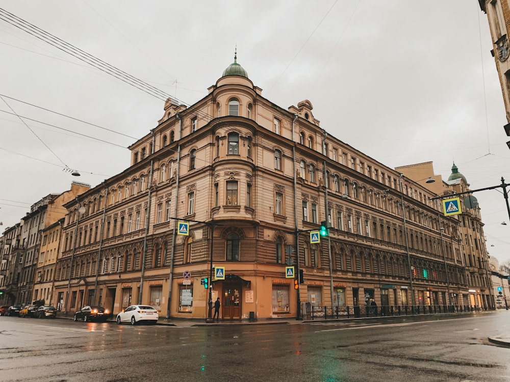 cars parked in front of brown building during daytime