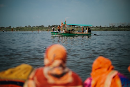 people in boat on water during daytime in Vrindavan India